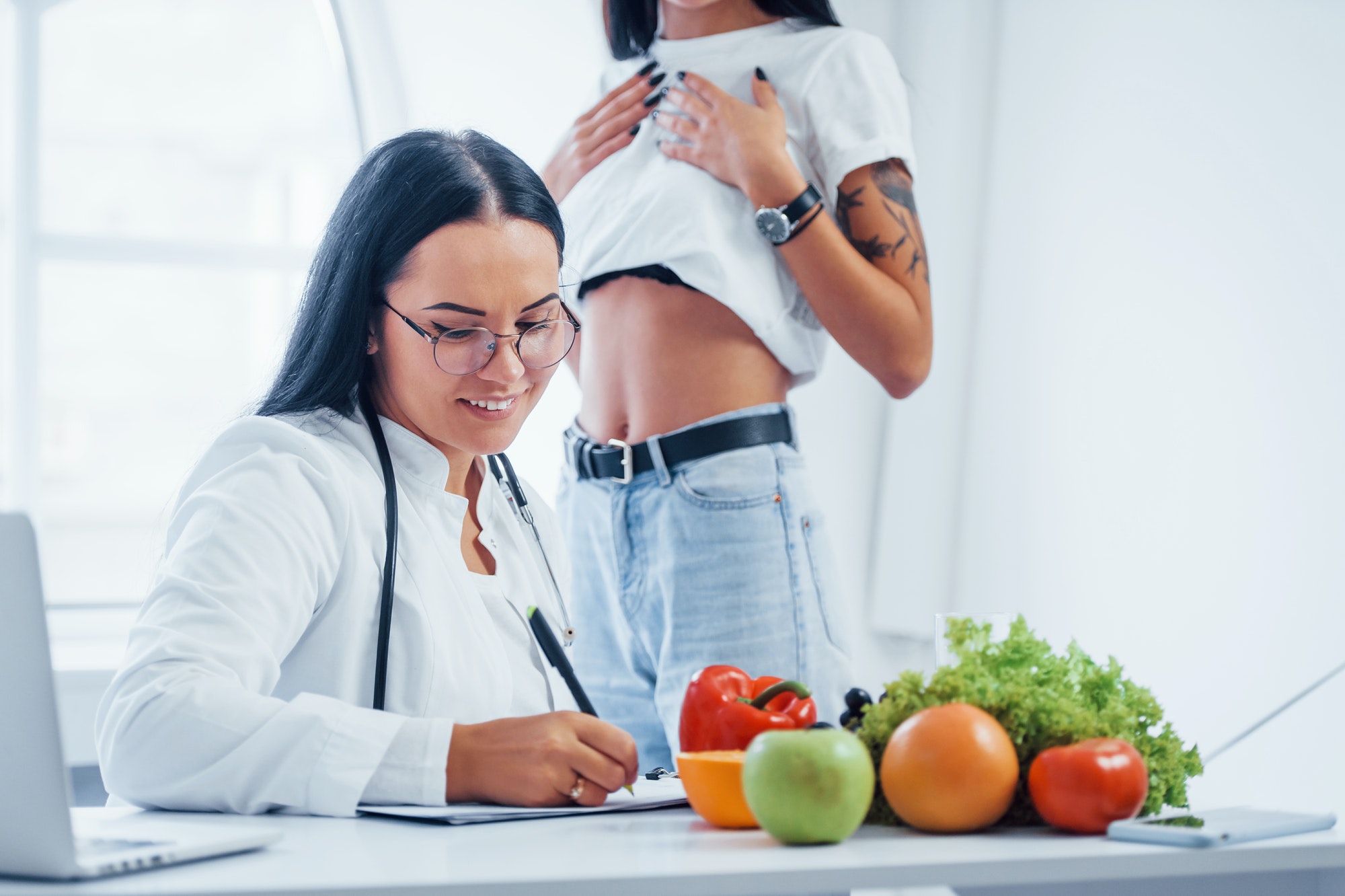 Female nutritionist gives consultation to patient indoors in the office