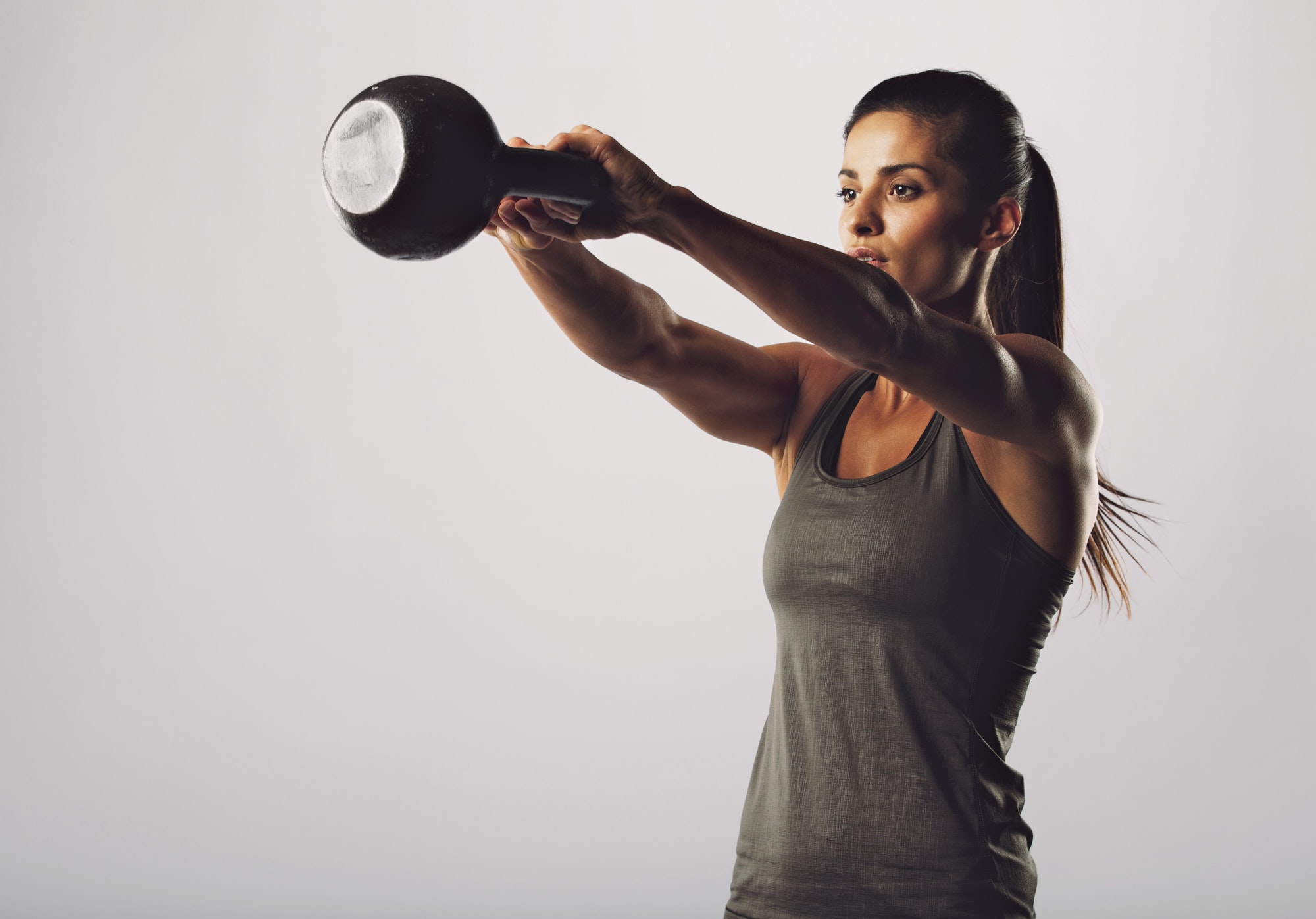 Attractive female doing kettle bell exercise