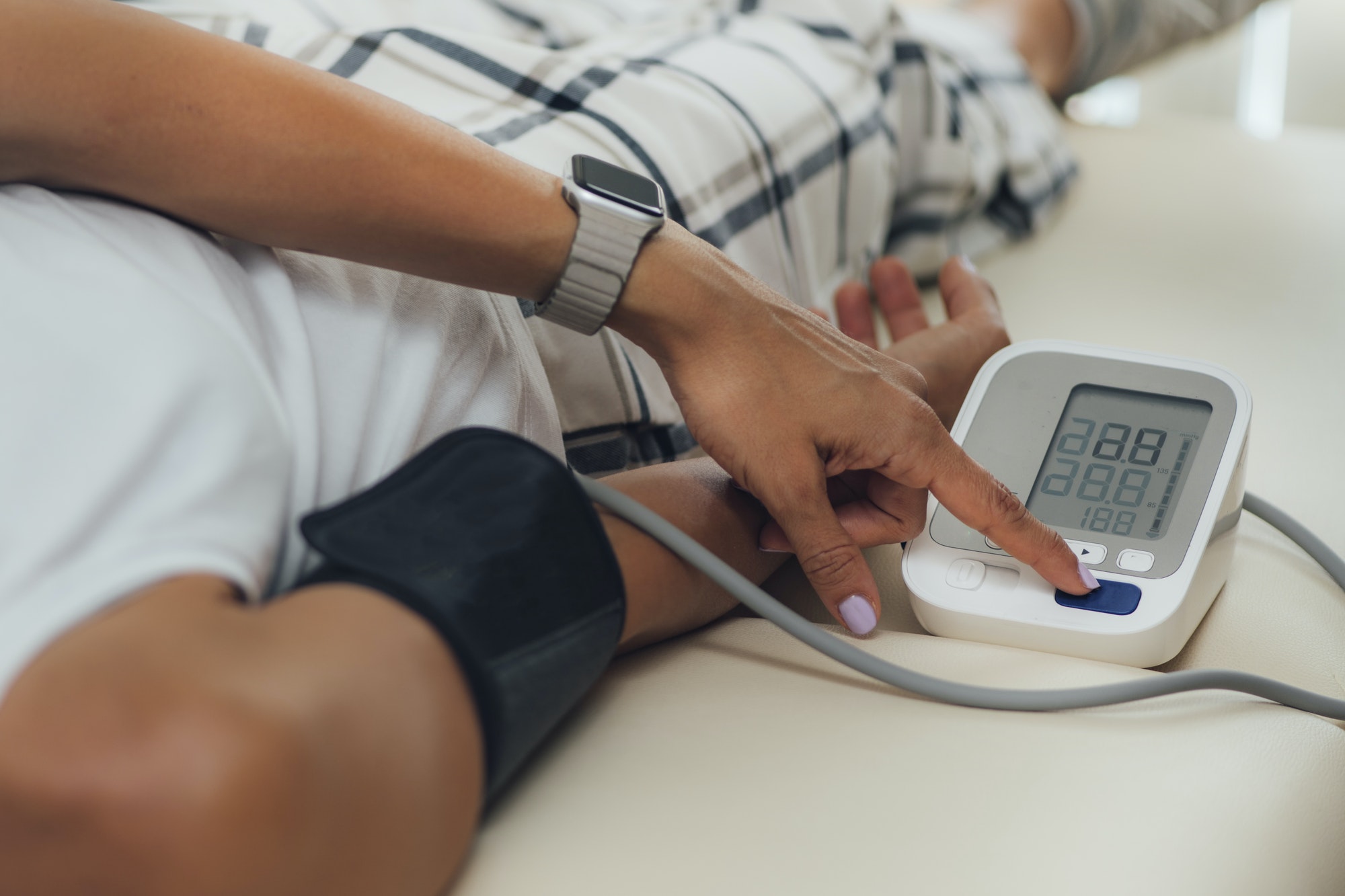 Orthostatic Blood Pressure. Woman Lying on Back and Measuring Blood Pressure on her Arm Orthostatic Blood Pressure. Woman Lying on Back and Measuring Blood Pressure on her Arm