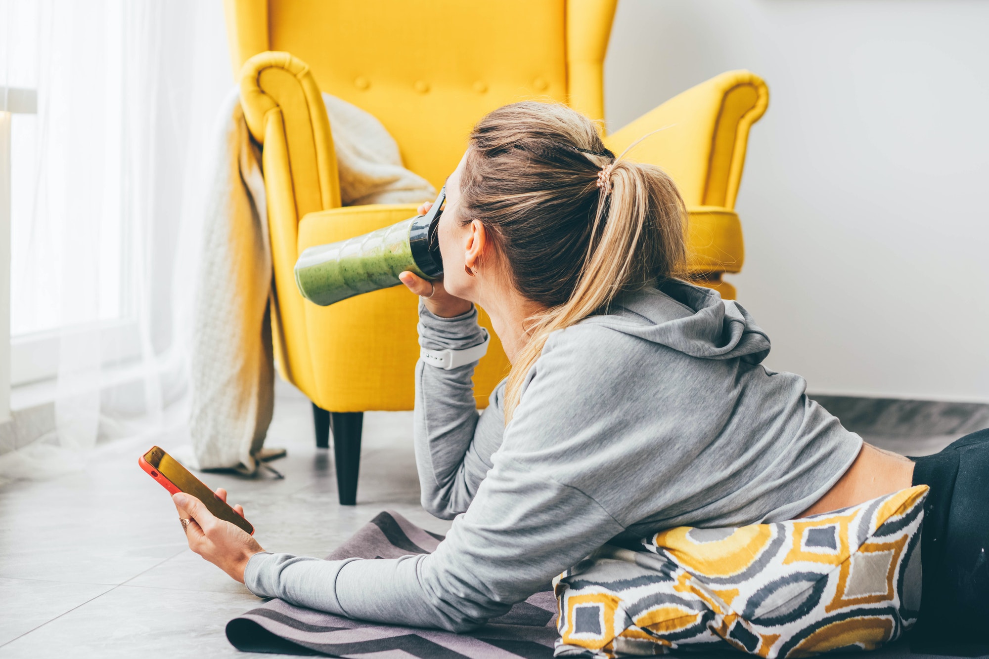 Beautiful woman drinking smoothie to refresh after workout.