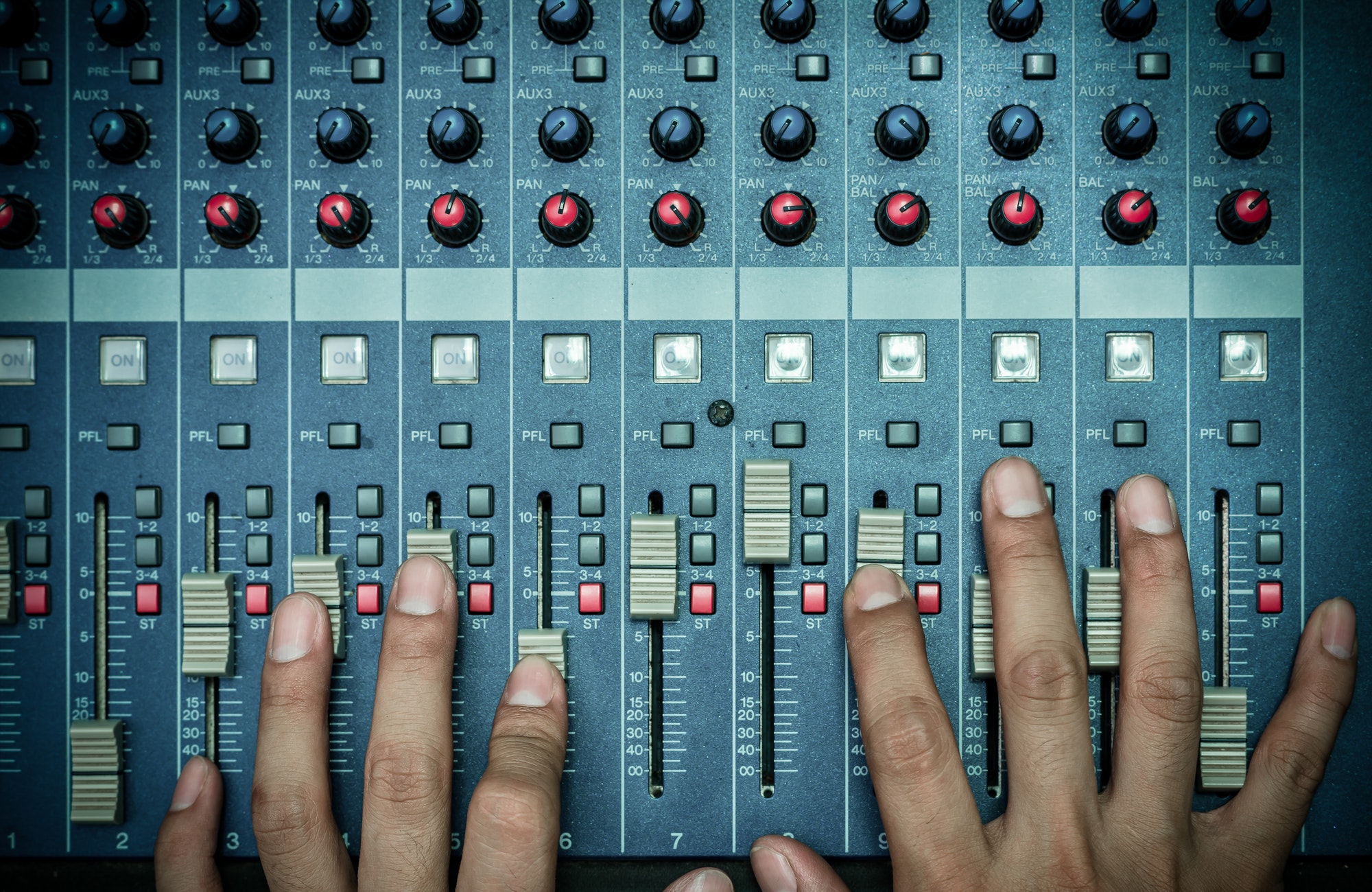 Top view of Hands adjusting audio mixer, music instrument concept