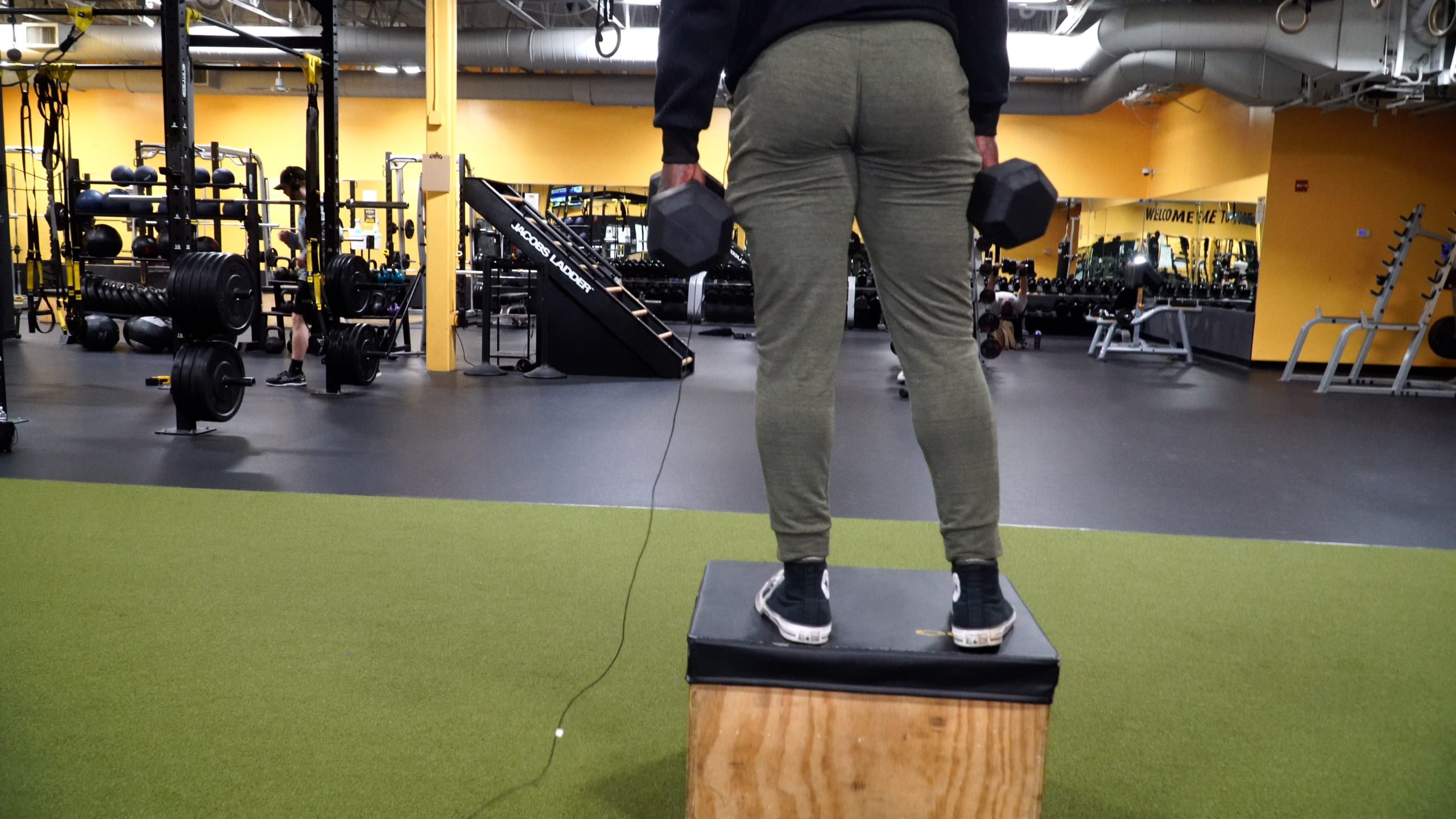 5 exercises leg workout YT tmumbnail man holding dumbbell standing on box